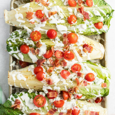 four grilled wedge salads displayed on a baking sheet