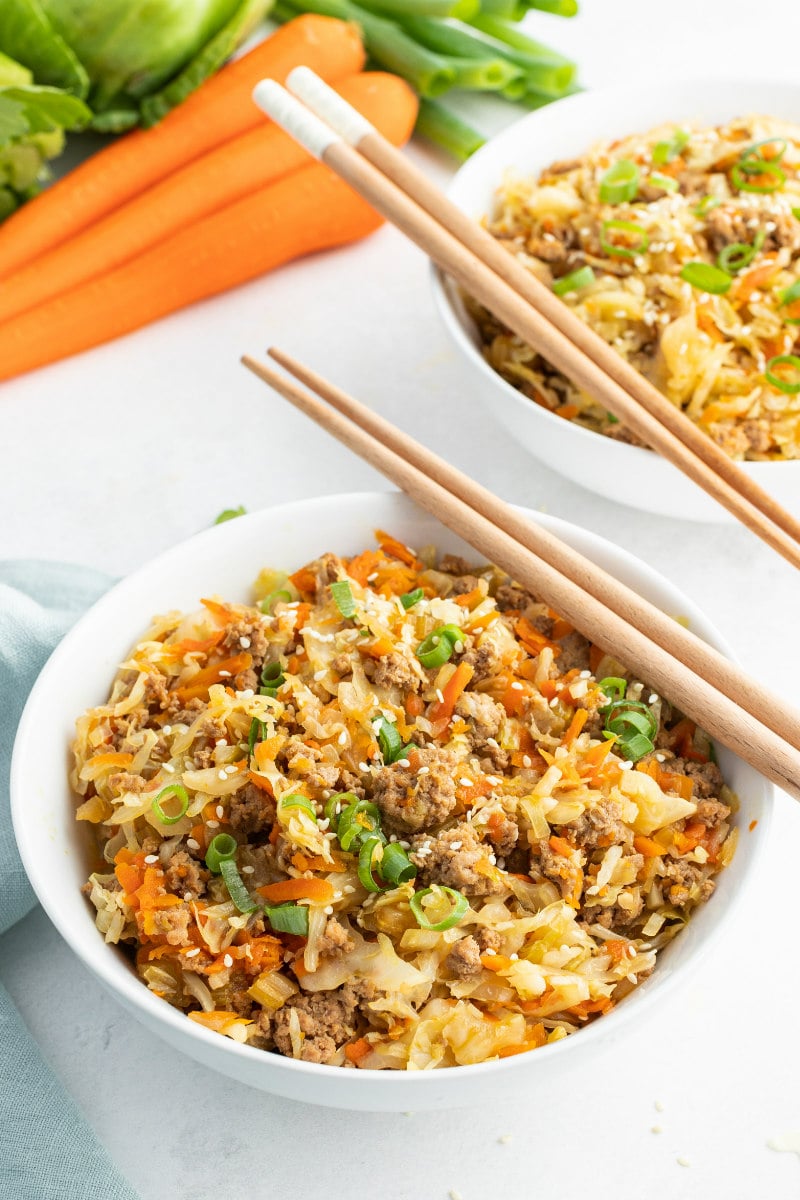 white bowl with egg roll and chopsticks