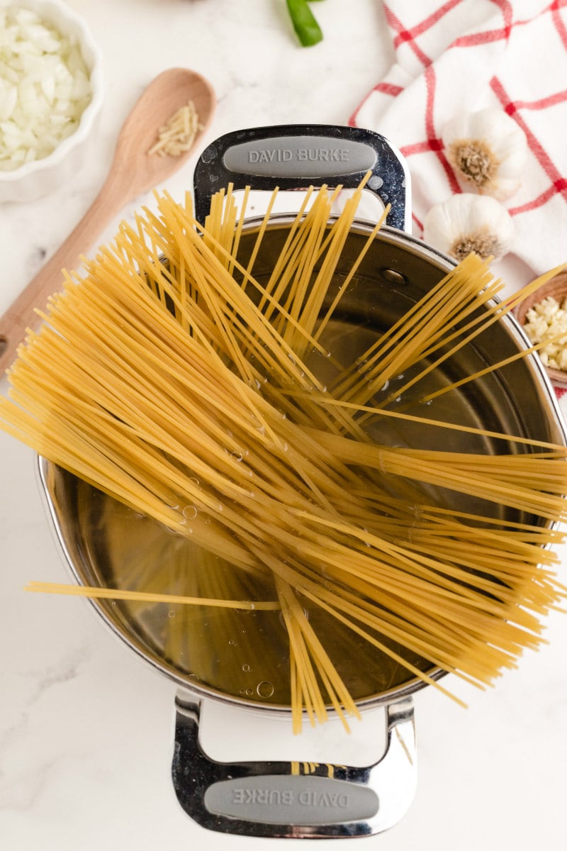 adding pasta to water in a pot