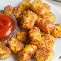 cauliflower tots on white plate served with ketchup