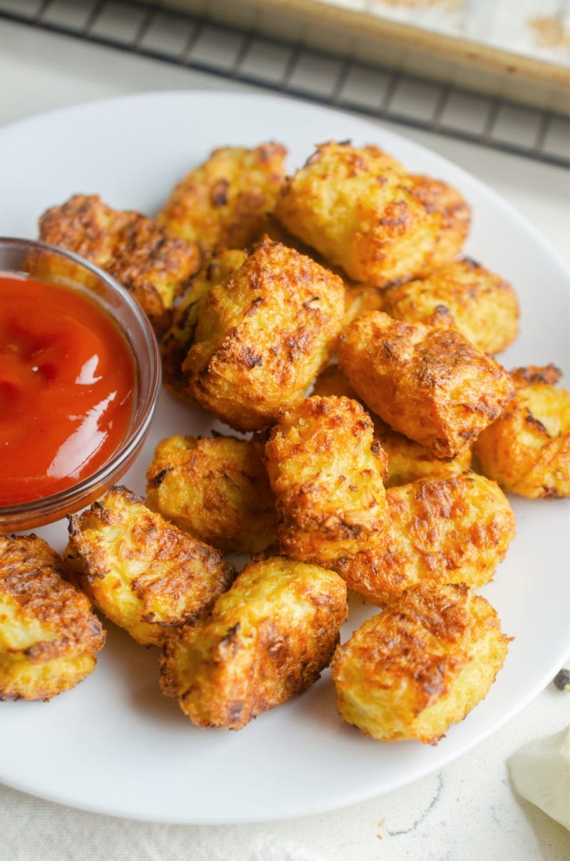 cauliflower tots on white plate served with ketchup