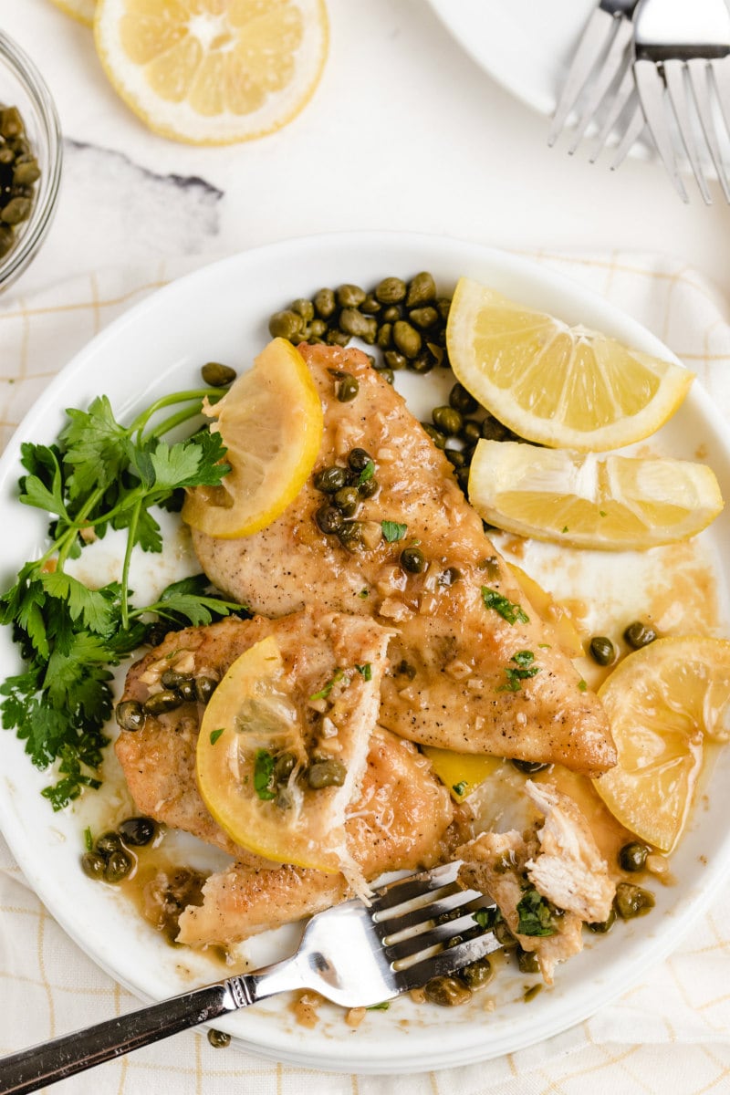 chicken piccata on a white plate with fork