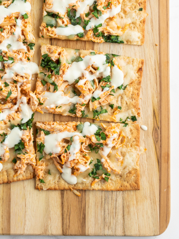 sliced buffalo chicken flatbread on cutting board