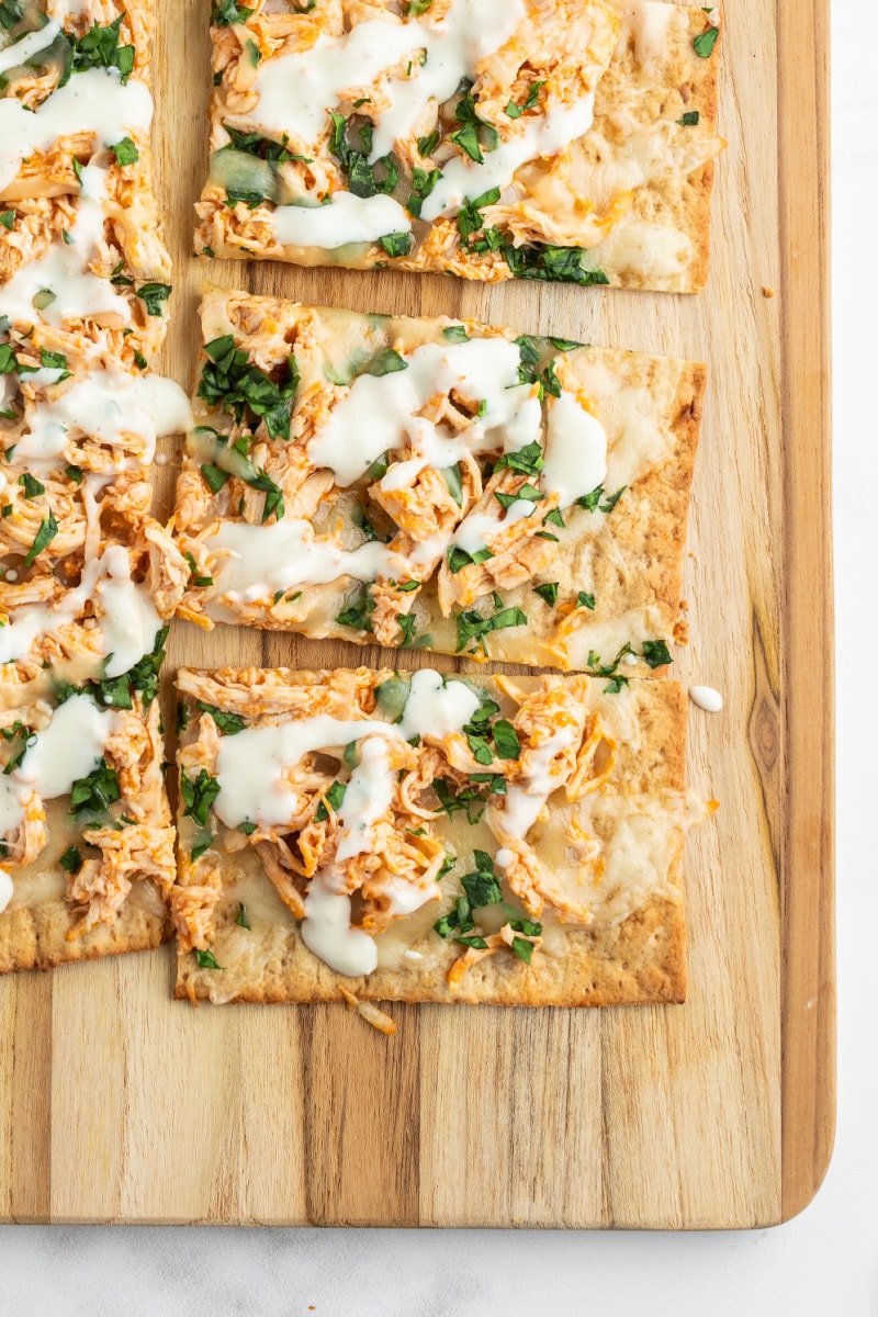 sliced buffalo chicken flatbread on cutting board