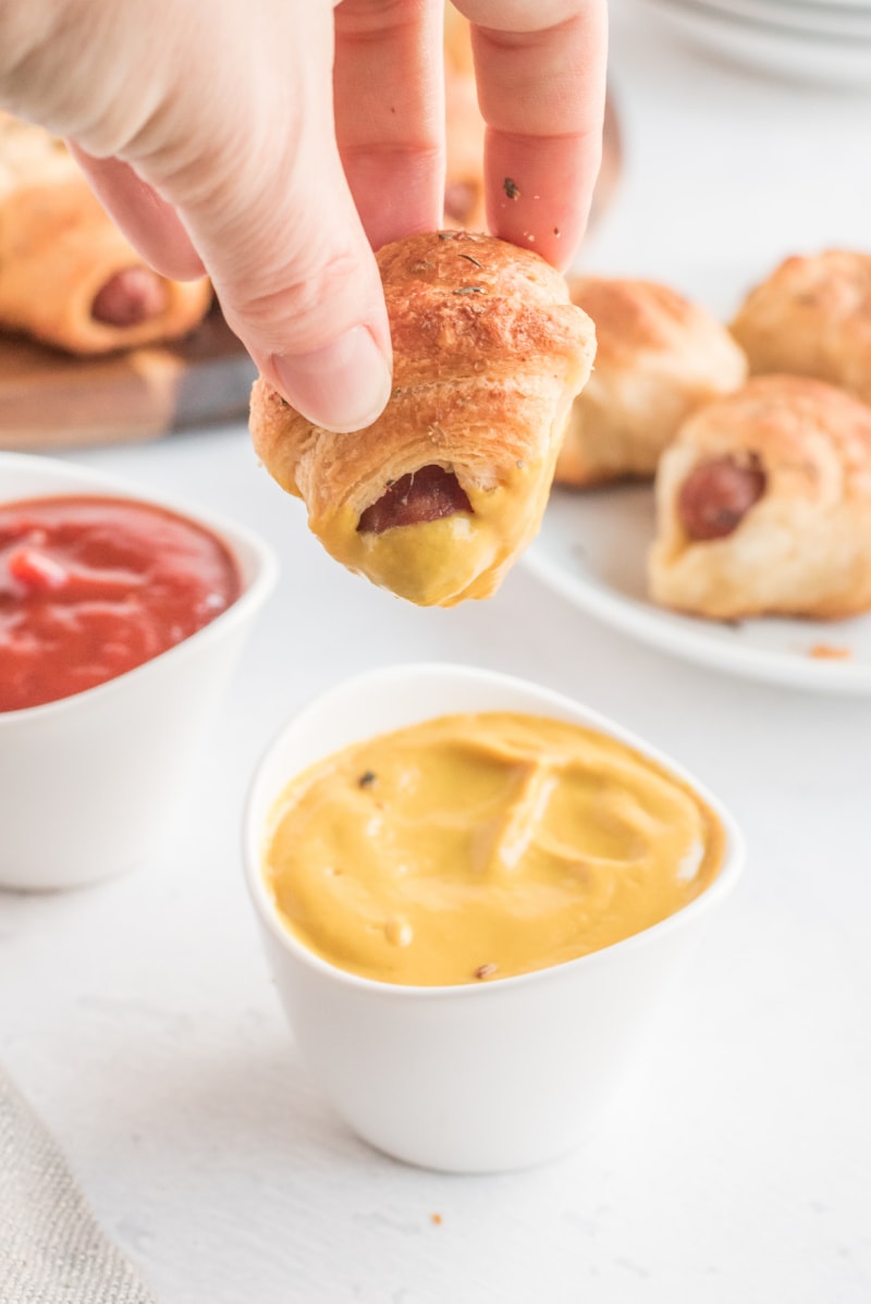 dipping pig in blanket in mustard