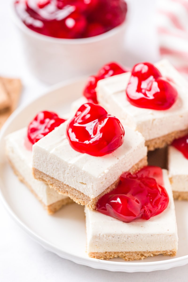 cherry cheesecake bars stacked on platter