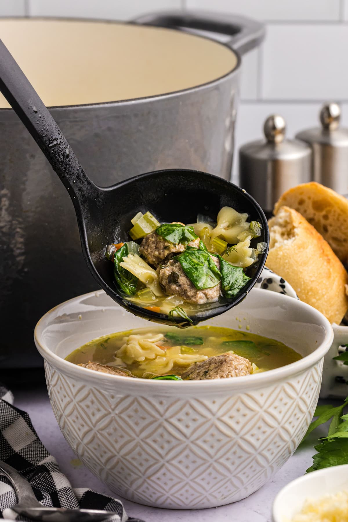 ladle putting soup into bowl