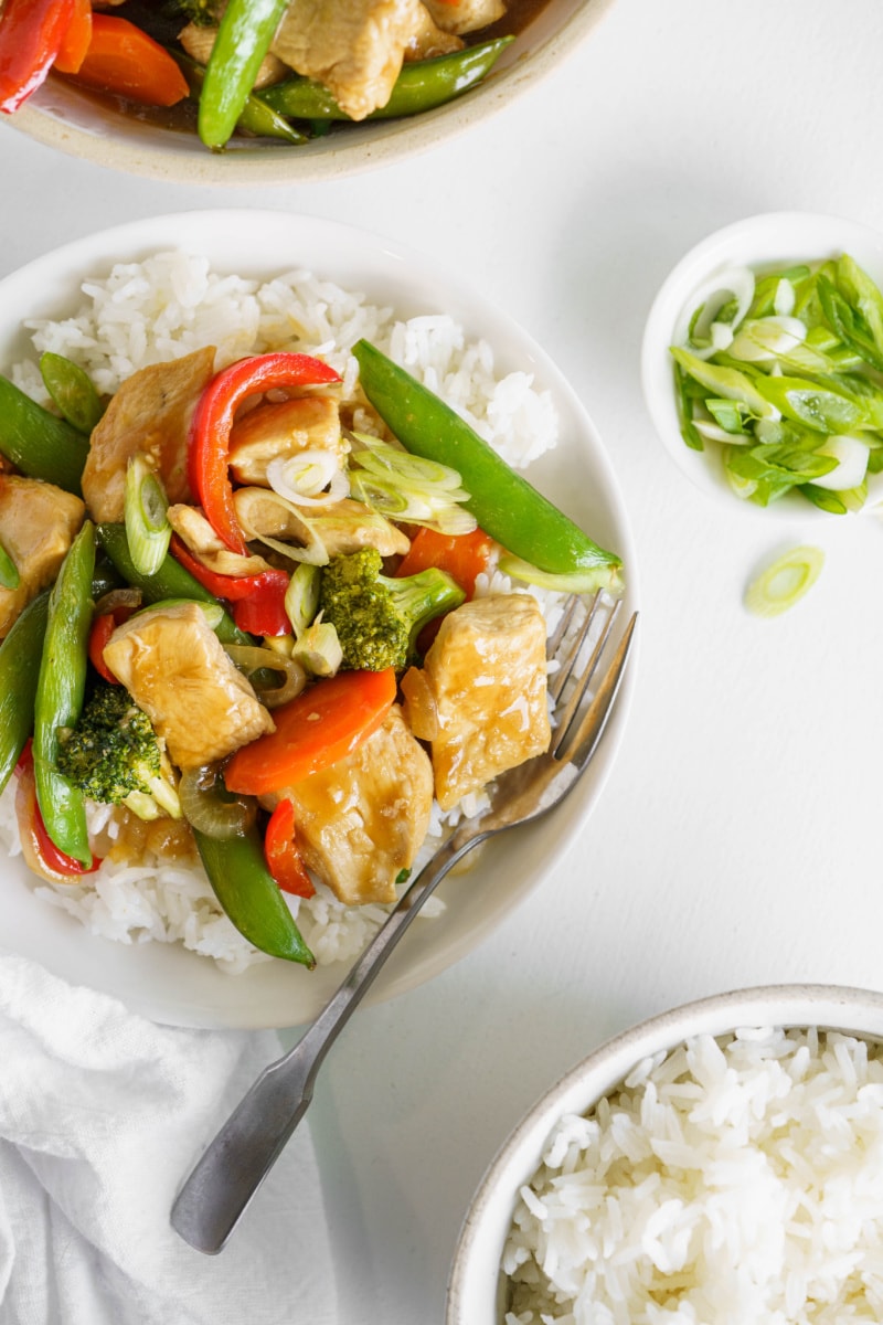 teriyaki chicken stir fry served on white plates with rice