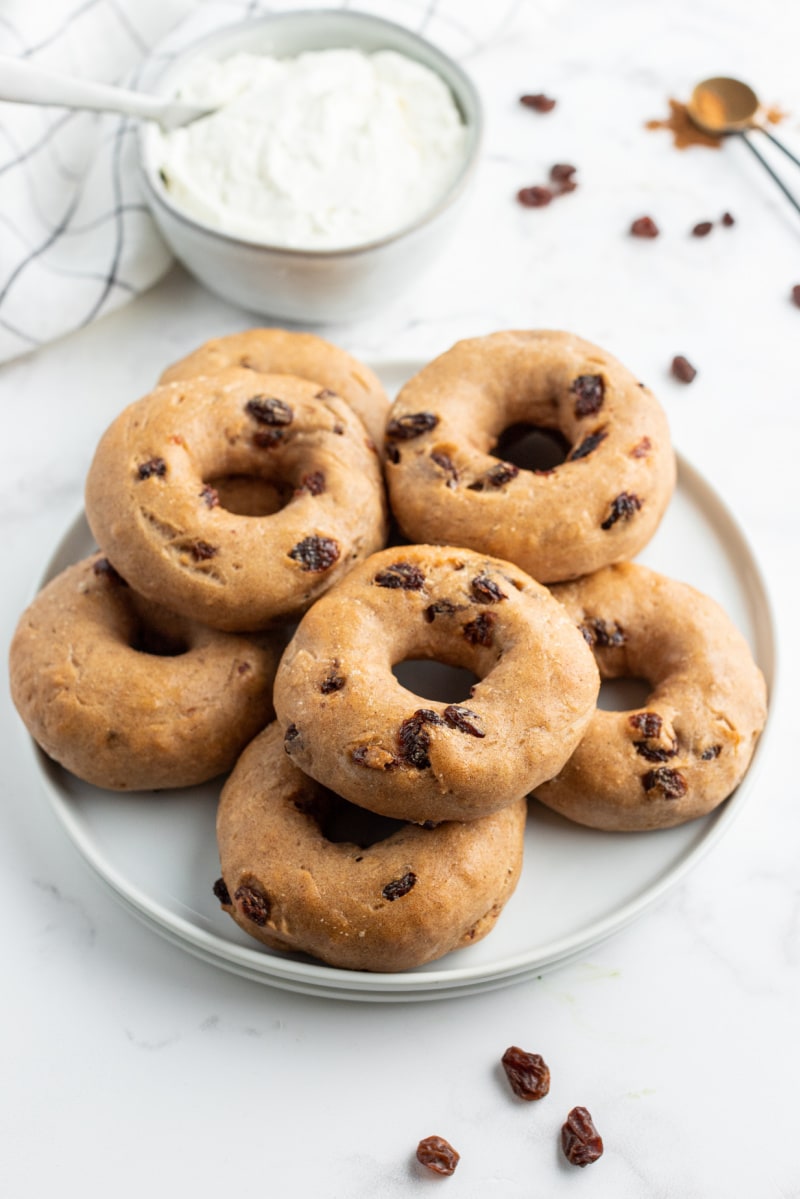 2 ingredient cinnamon raisin bagels on white plate with bowl of cream cheese