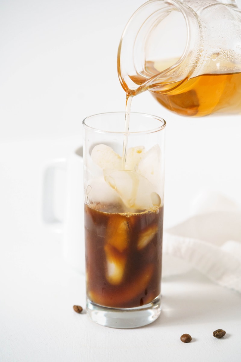 vanilla syrup pouring into iced coffee