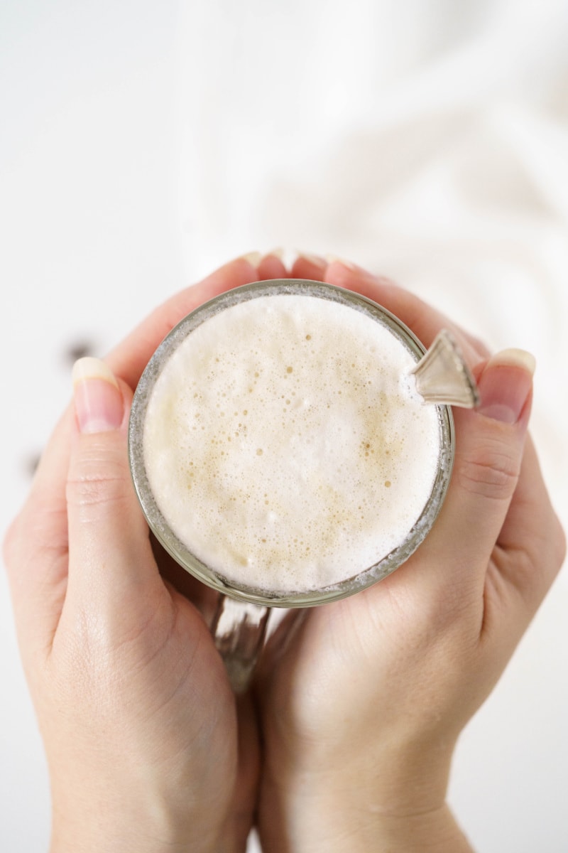 hands holding a latte overhead shot