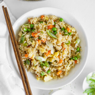 vegetable fried rice in a white bowl with chopsticks