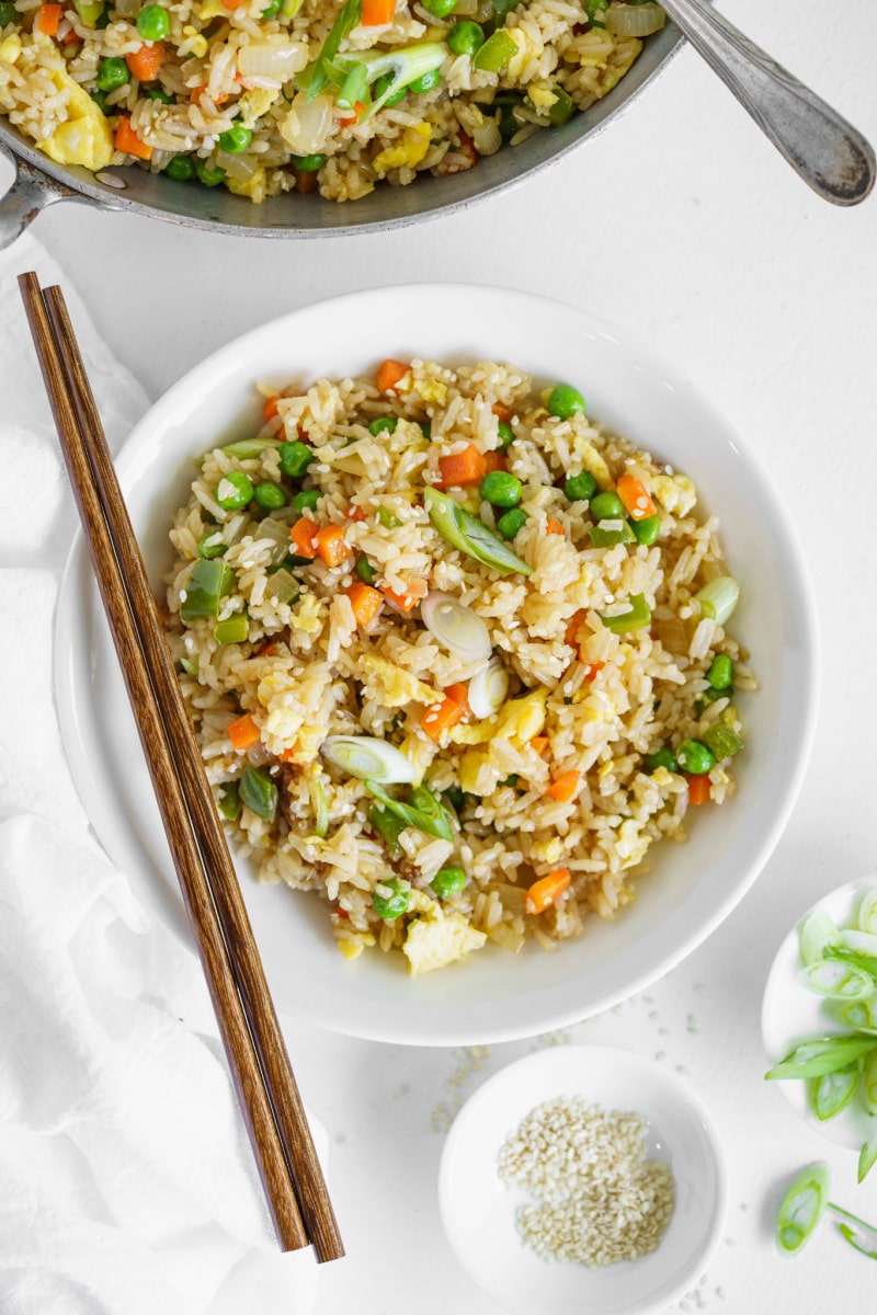 vegetable fried rice in a white bowl with chopsticks