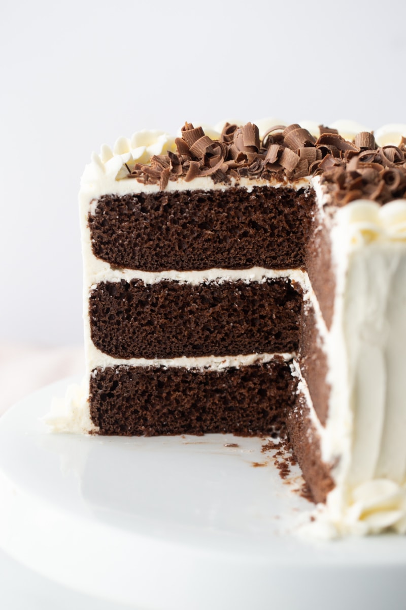 chocolate wedding cake with white frosting and chocolate shavings on top cut into to see inside