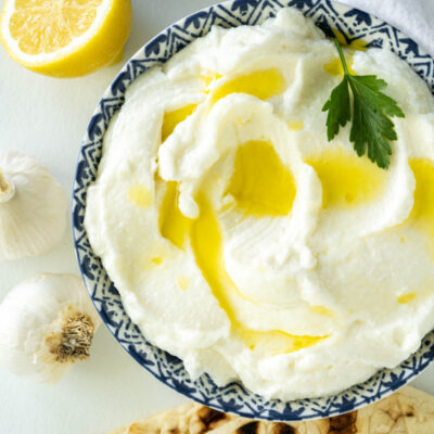 lebanese garlic dip in a bowl with pita on side