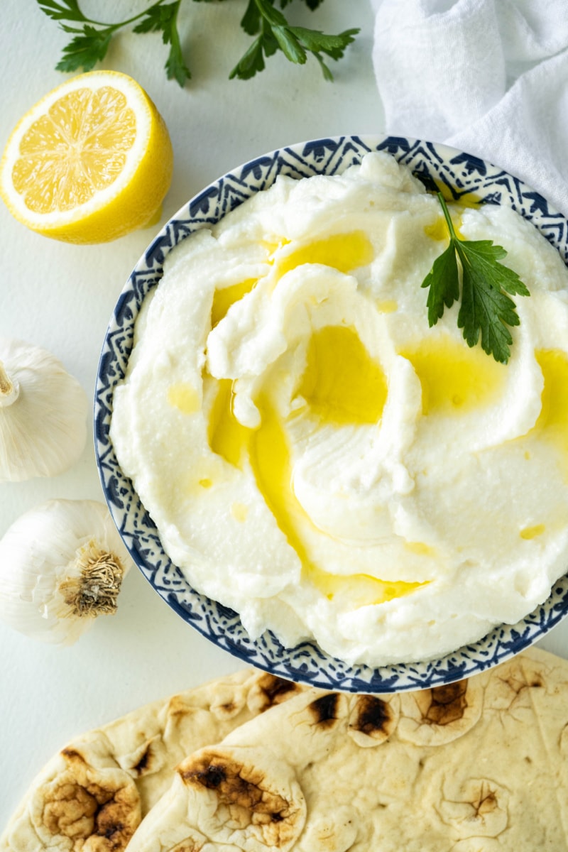 lebanese garlic sauce in a bowl with pita on side