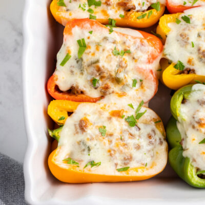 philly cheesesteak stuffed peppers in a white casserole dish