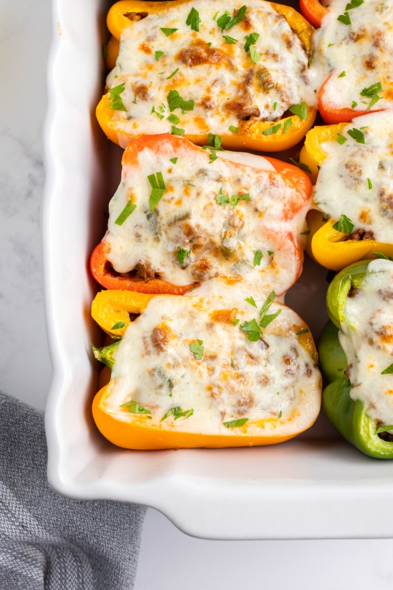 philly cheesesteak stuffed peppers in a white casserole dish