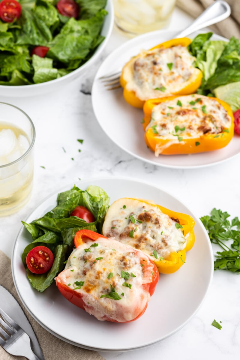 philly cheesesteak stuffed peppers on white plates for serving