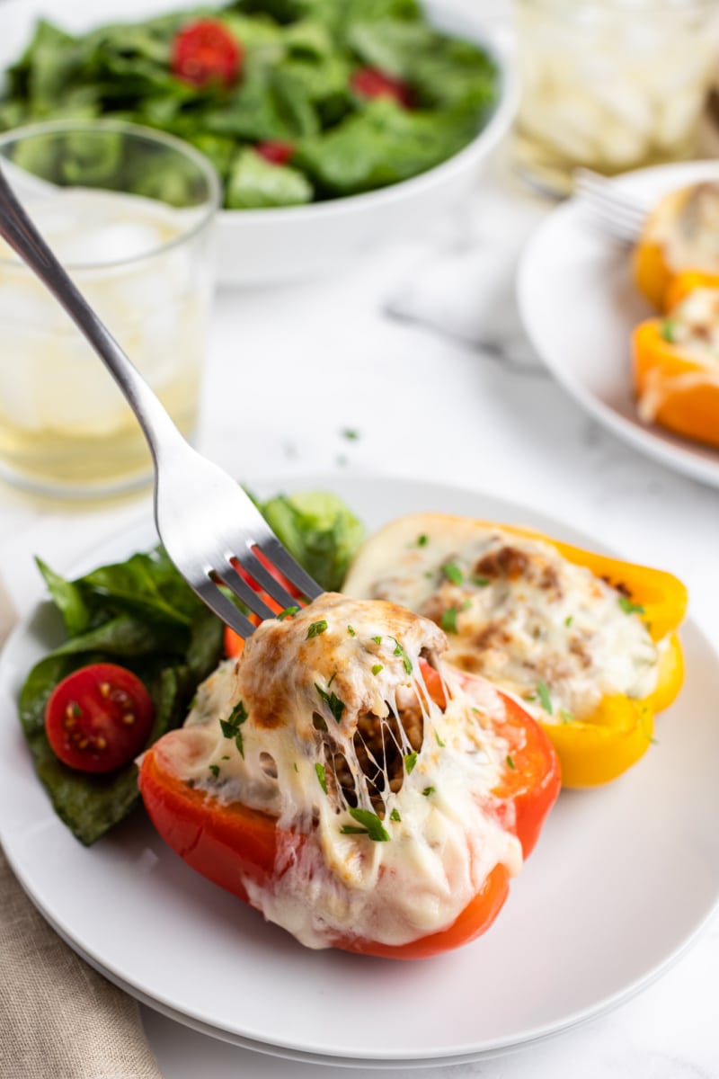 fork pulling cheese out of a philly cheesesteak stuffed pepper