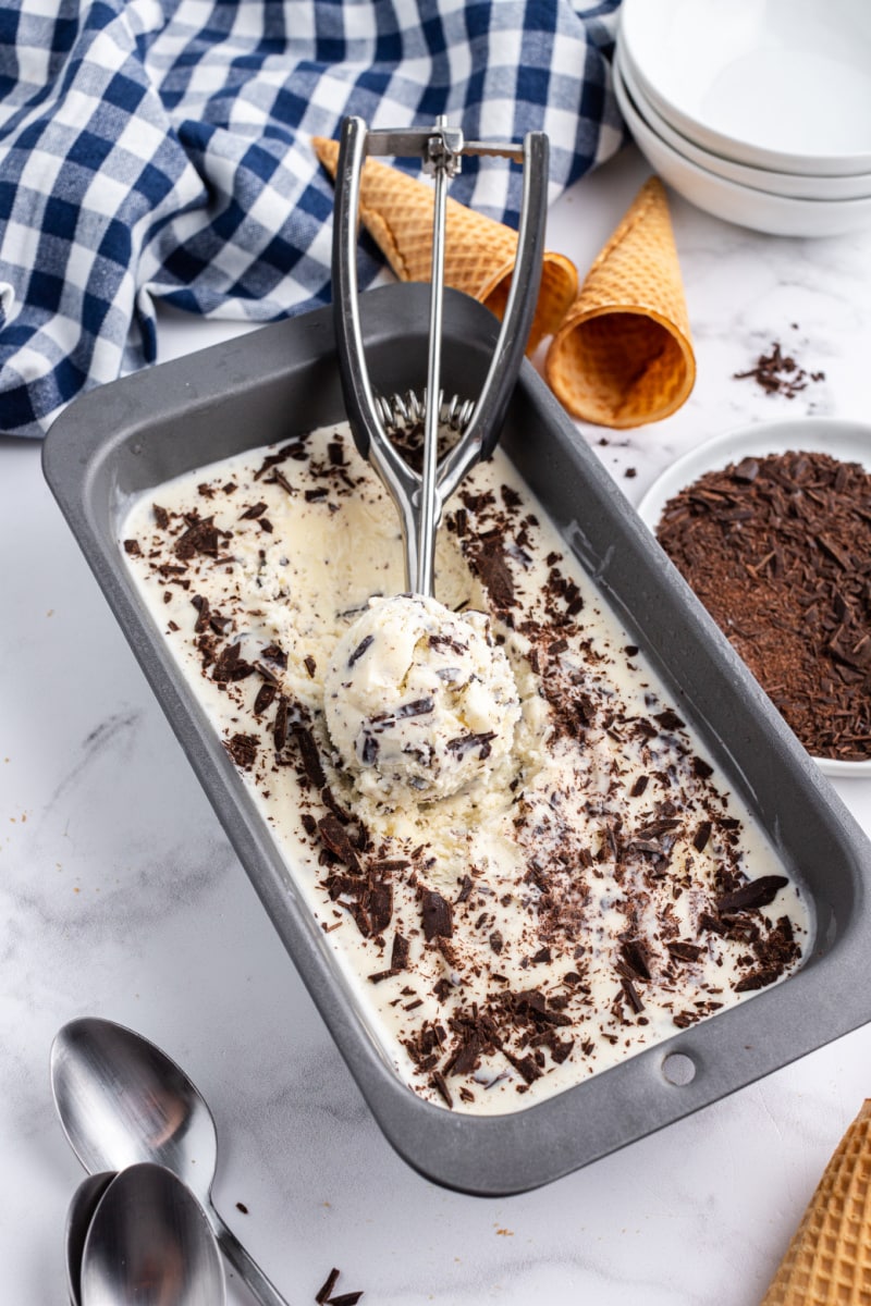 tub of stracciatella gelato with ice cream scoop of it inside