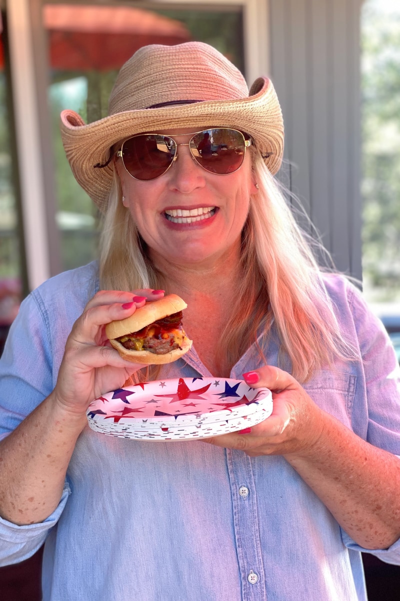Cowboy Sliders recipe from RecipeGirl.com #cowboy #sliders #recipe #RecipeGirl RecipeGirl in cowboy hat eating a slider