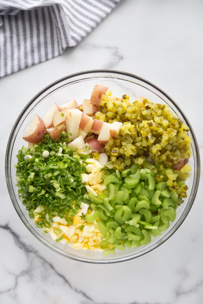 dill pickle potato salad ingredients in bowl ready to add dressing