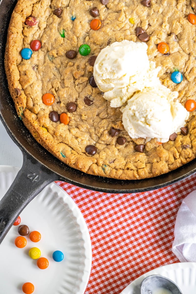 monster skillet cookie in black iron skillet with vanilla ice cream on top