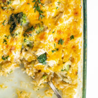 chicken broccoli and rice cheesy casserole in a casserole dish with serving taken out