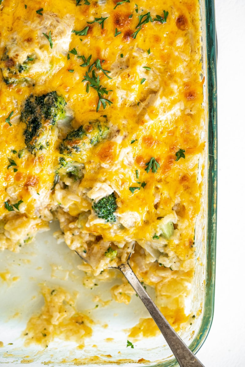 chicken broccoli and rice cheesy casserole in a casserole dish with serving taken out