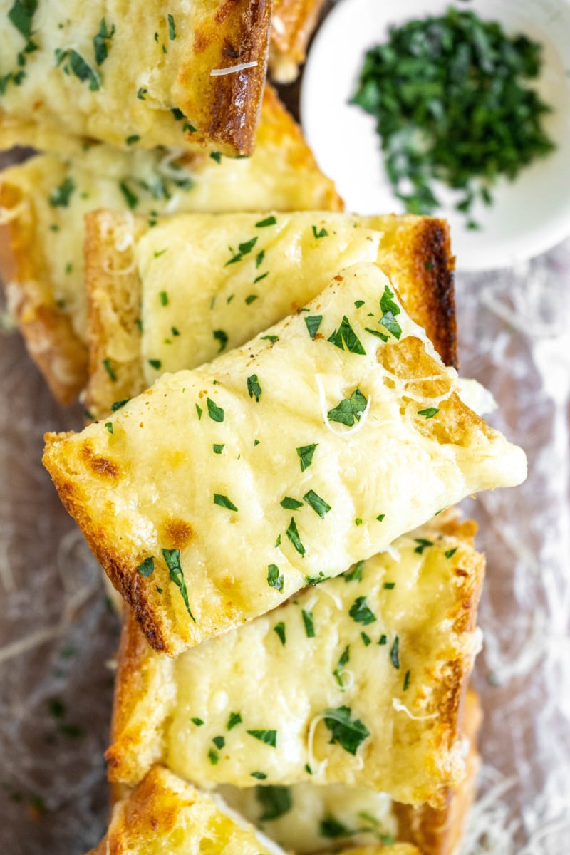 slices of cheesy garlic bread stacked on plate
