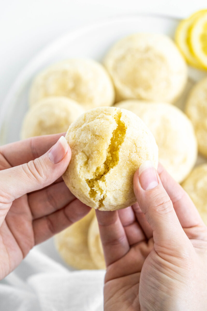 hands breaking apart a sugar cookie