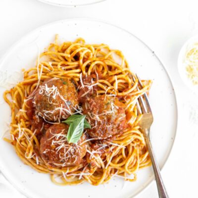 spaghetti and meatballs on a white plate