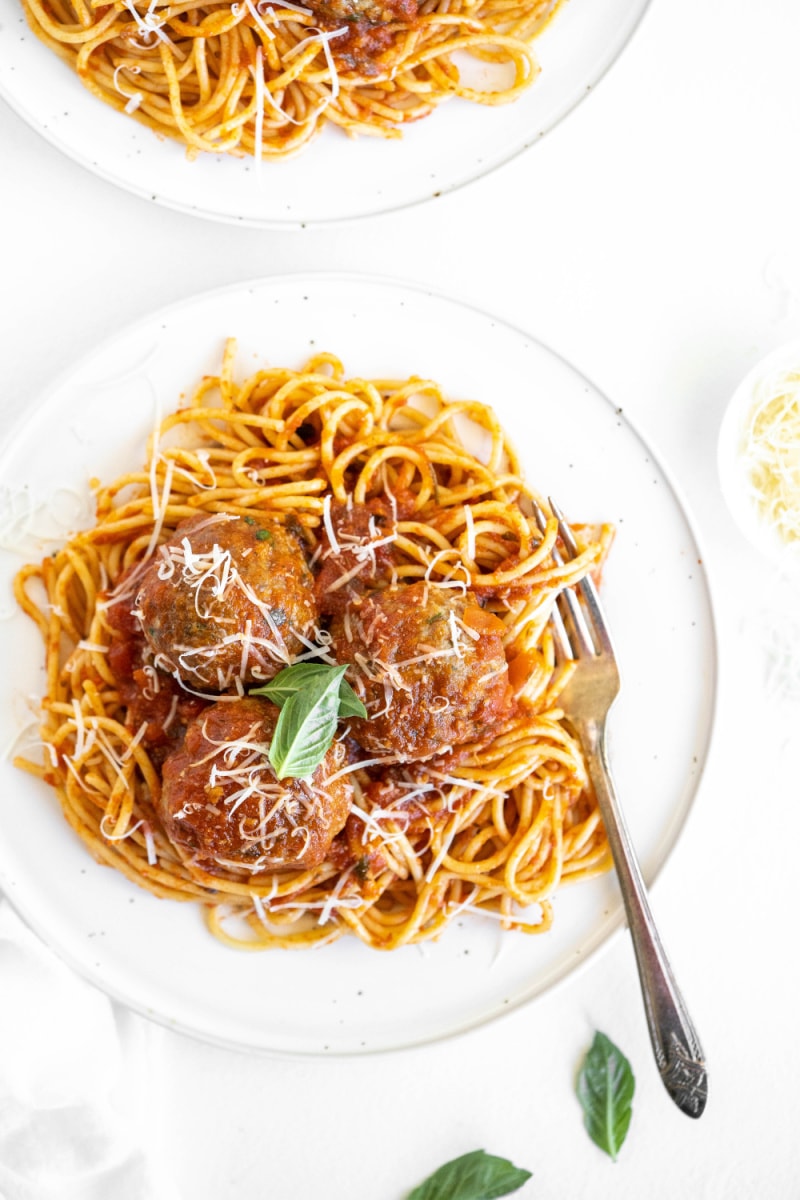 spaghetti and meatballs on a white plate