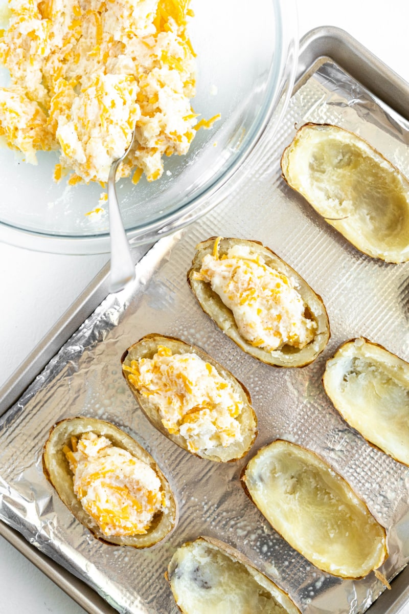 filling hollowed out potatoes with filling to bake