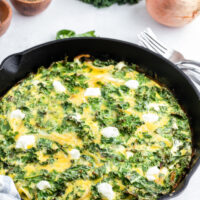 kale and goat cheese frittata in a black skillet