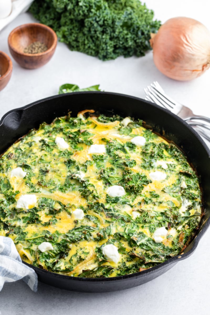 kale and goat cheese frittata in a black skillet