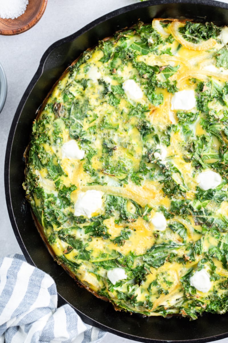 kale and goat cheese frittata in black skillet