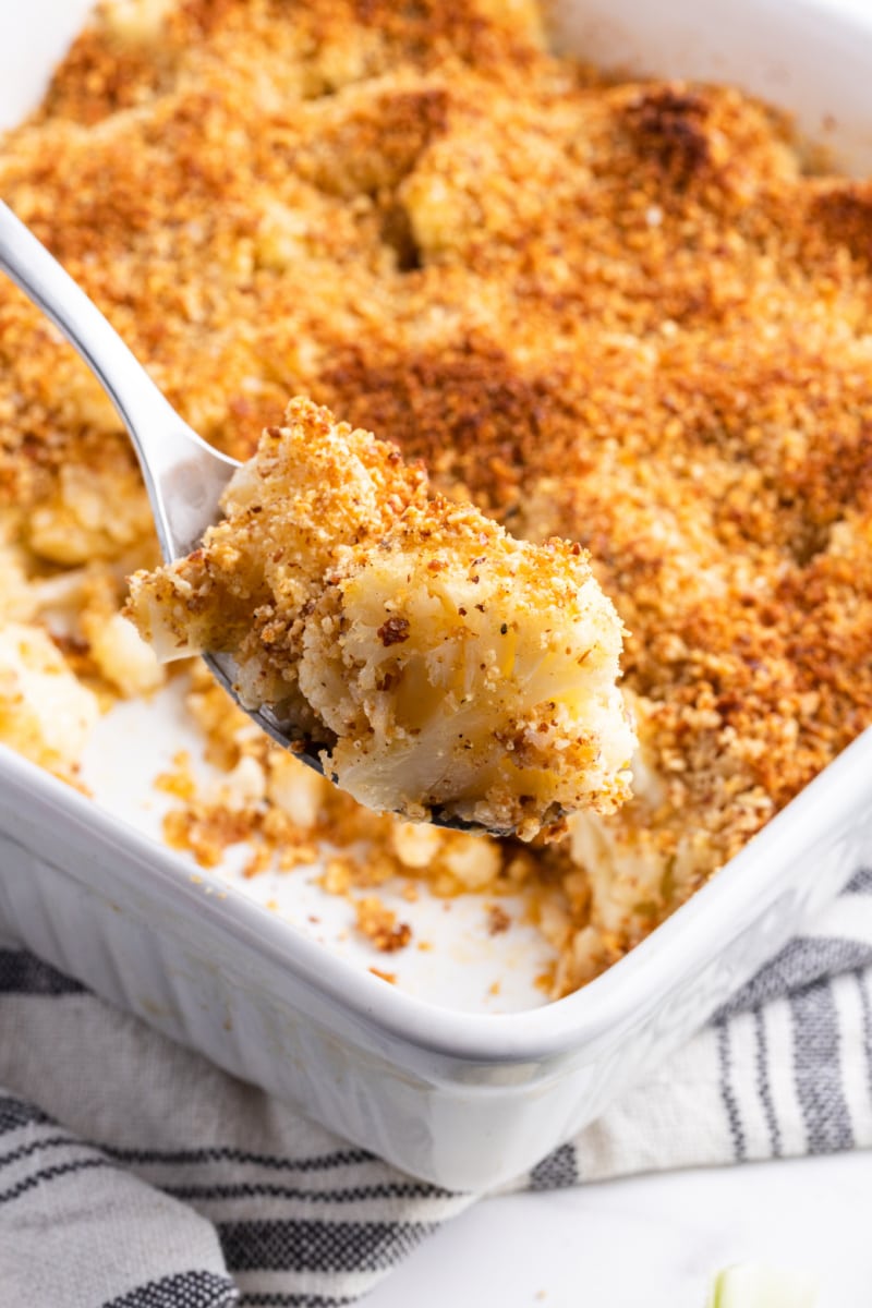 spooning out smoky cauliflower gratin out of casserole dish