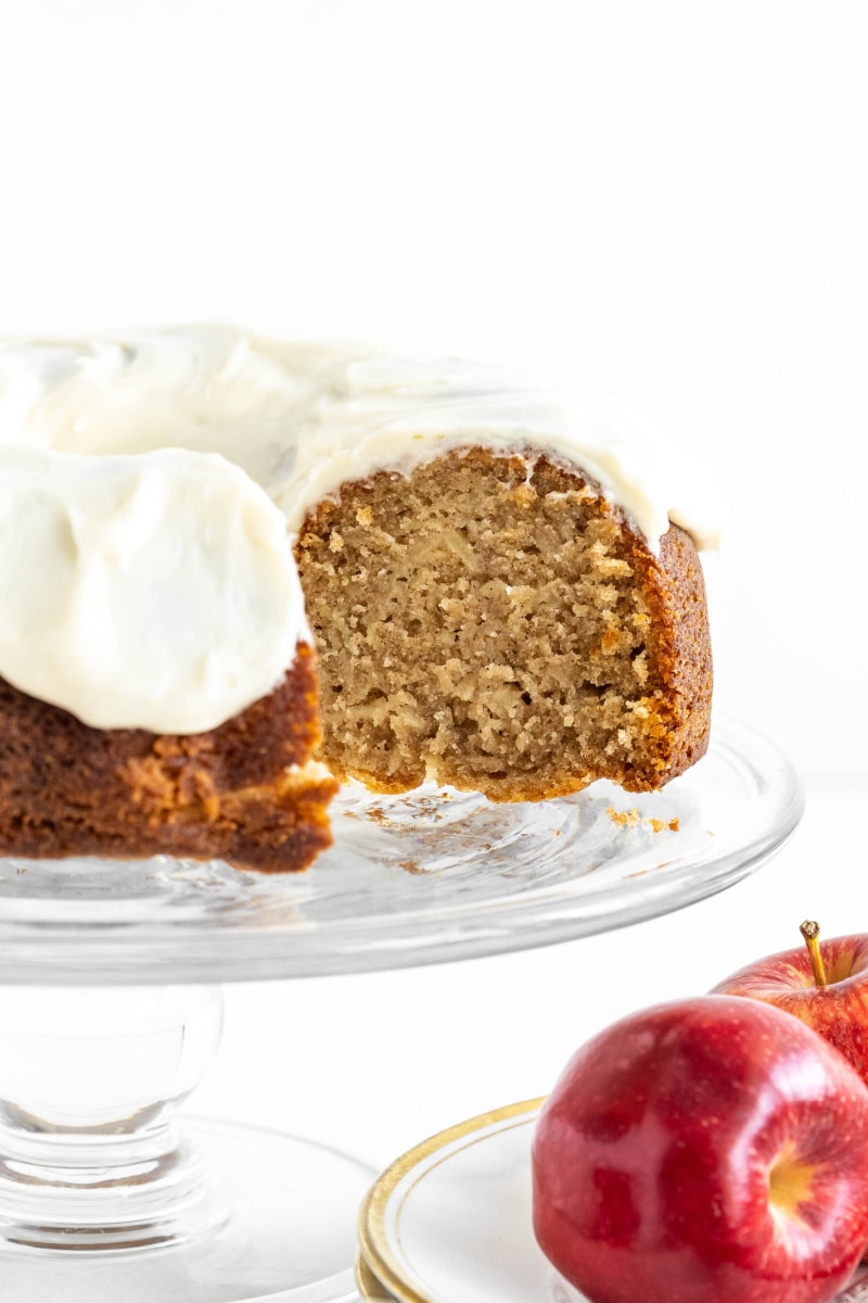 apple bundt cake with cream cheese frosting on cake platter