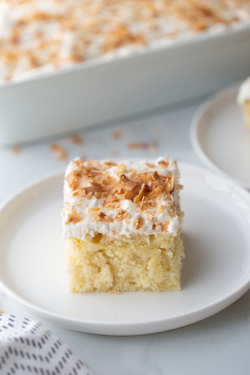 slice of coconut sheet cake on a white plate