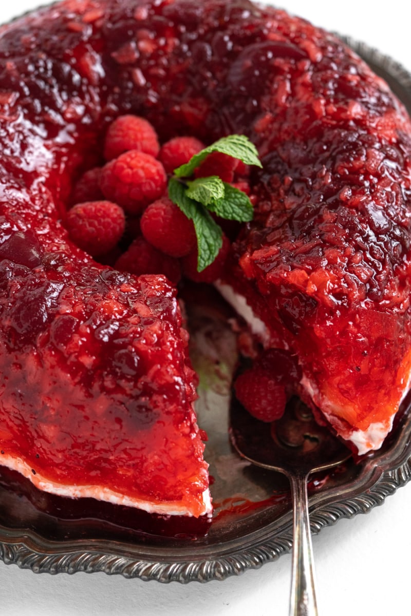 cranberry jello ring with a slice taken out of it