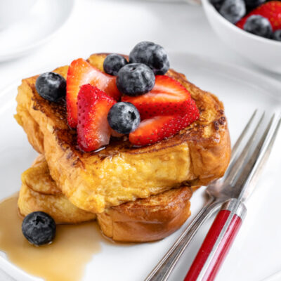 french toast topped with berries and syrup