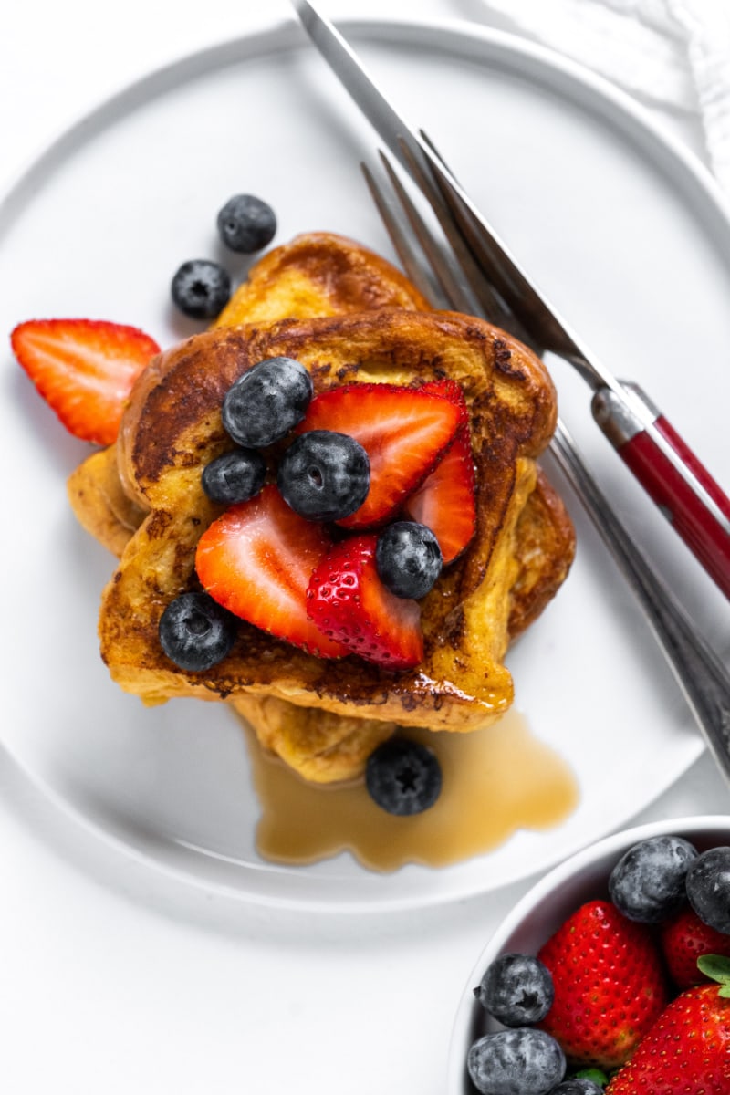 french toast on a plate topped with berries