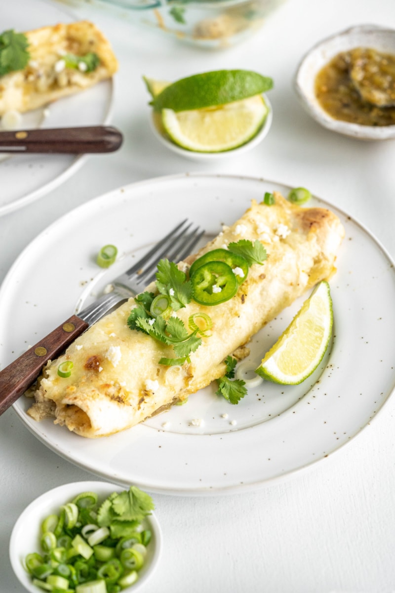 salsa verde chicken enchilada on a plate