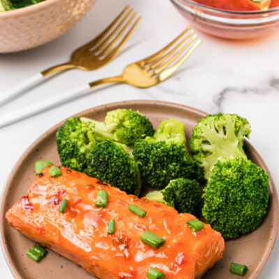 sweet and spicy air fryer salmon on a plate with broccoli