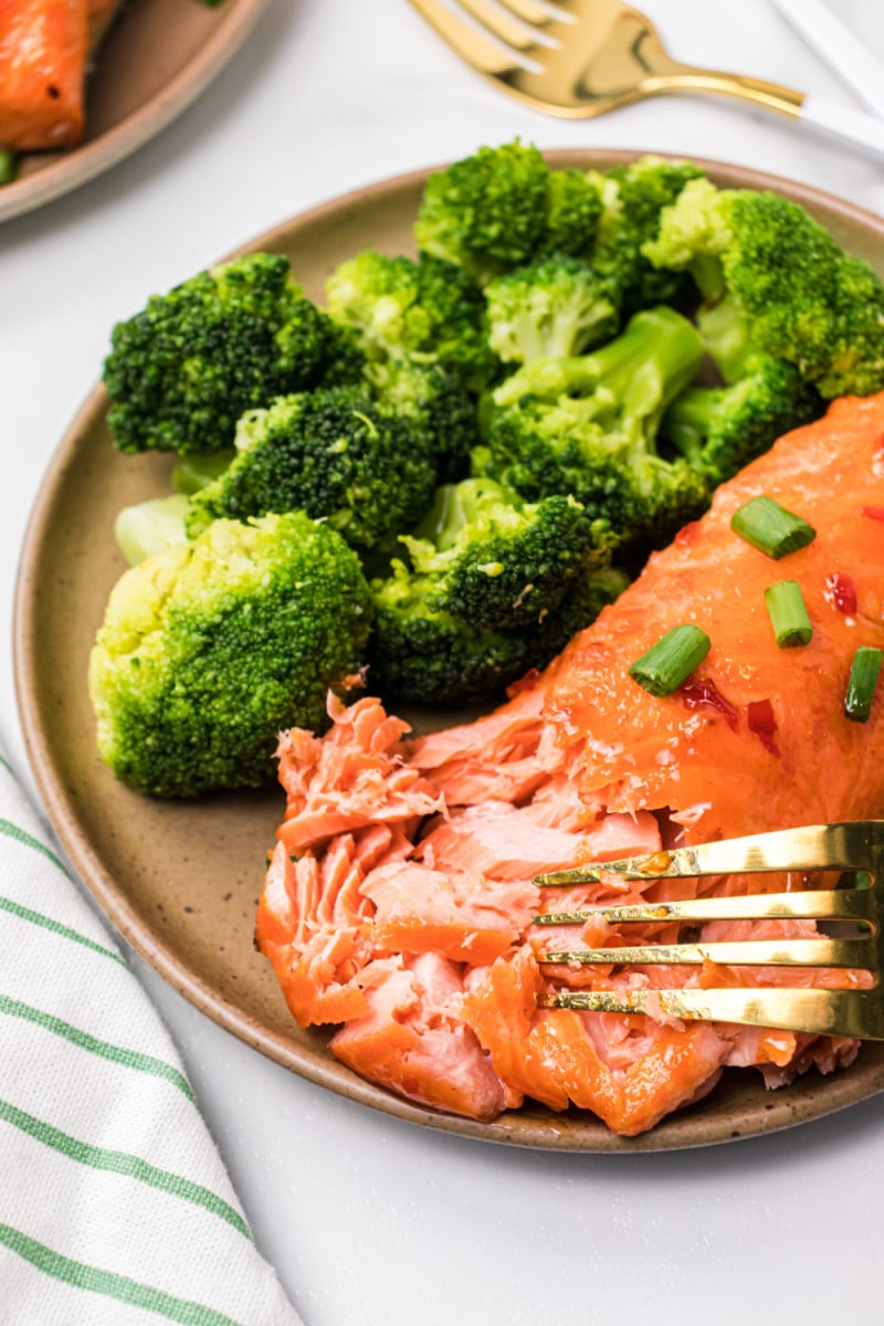 sweet and spicy air fryer salmon on a plate with a fork flaking it