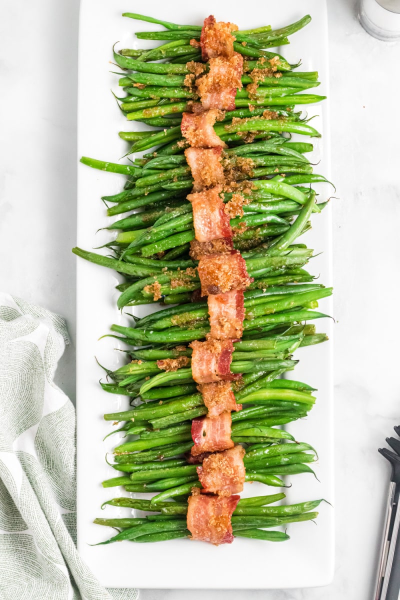 bacon wrapped green beans on a white platter