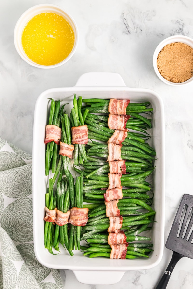 bacon wrapped green beans in a white baking dish