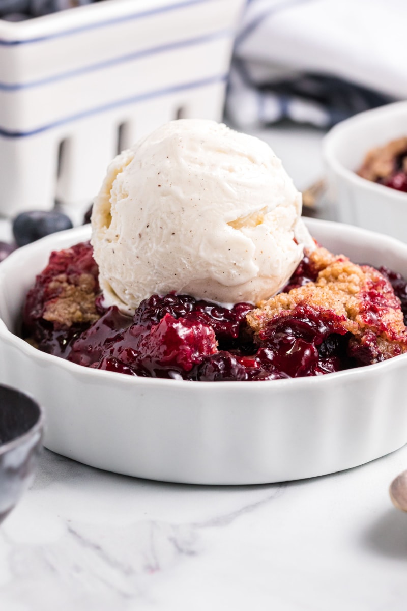 berry crumble served in dish with vanilla ice cream
